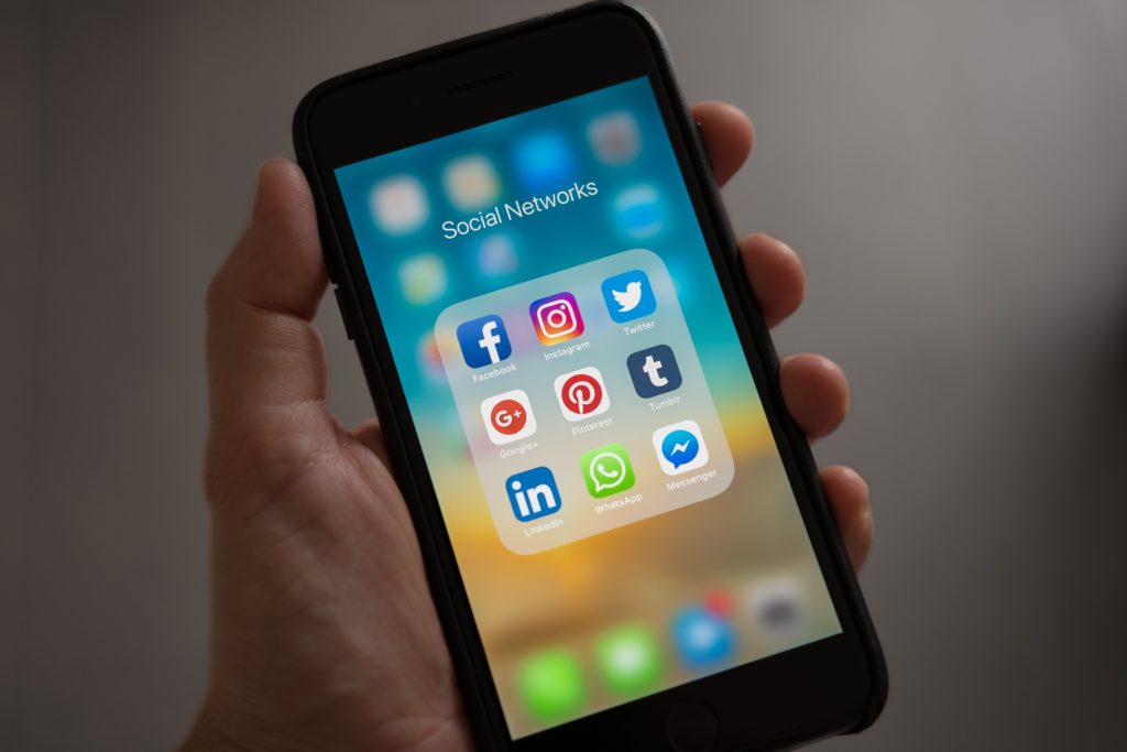 As redes sociais são fundamentais na aplicação do marketing digital pois são o veiculo das mensagens que queremos passar. Esta imagem mostra um smartphone ligado a visualizar as redes sociais. Uma forma de aumentar os resultados é através da publicidade paga nestas redes.